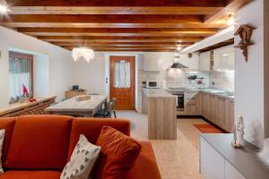 a kitchen and living room with a couch and a table at Appartamento Zopel in Falcade
