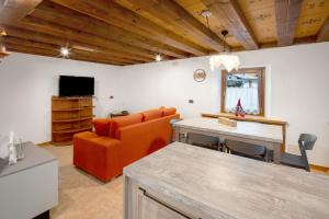 a living room with an orange couch and a table at Appartamento Zopel in Falcade