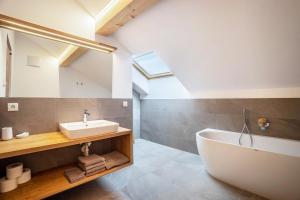 a bathroom with a white tub and a sink at Residence Linderhof in Natz-Schabs +162 photos