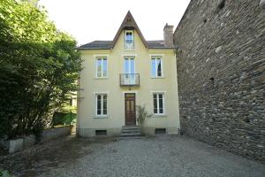 a yellow house with a brick wall and a door at Le Clos du Casino in Luchon