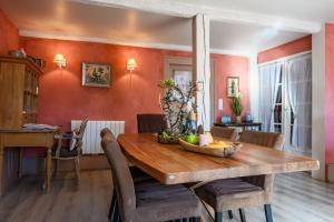 a dining room with a wooden table and chairs at Demeure D'antan - Chambres d'hôtes in Beblenheim