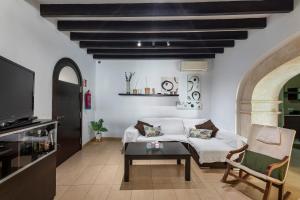 a living room with a white couch and a table at Casa típica mallorquina en Sa Pobla in Sa Pobla
