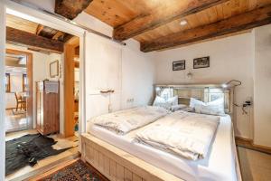 a large bed in a room with wooden ceilings at Schuler-Haus in Balingen