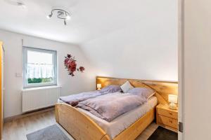 a bedroom with a wooden bed and a window at Ferienwohnung Nickel in Hofstetten