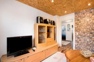 a living room with a television on a wooden cabinet at Ferienwohnung Nickel in Hofstetten