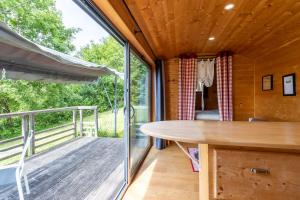 a dining room with a table and a balcony at Tiny House, Clim et Bassin in Auriac-du-Périgord +16 photos