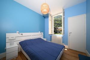 a blue bedroom with a bed and a window at Le Clos du Casino in Luchon