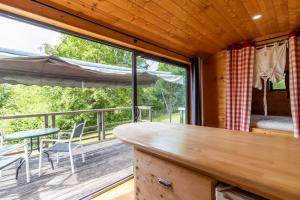 a kitchen with a table and chairs on a balcony at Tiny House, Clim et Bassin in Auriac-du-Périgord