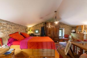 a bedroom with a large bed in a room with stone walls at Villa L'Elzède in Les Vans