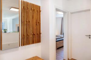 a hallway with a wooden wall panel and a mirror at Manu's Bergblick in Arzl im Pitztal +19 photos