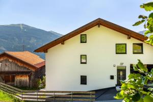 a white house with a brown roof at Manu's Bergblick in Arzl im Pitztal