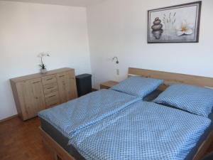a bedroom with two beds and a picture on the wall at Ferienwohnung Stadtblick in Bräunlingen