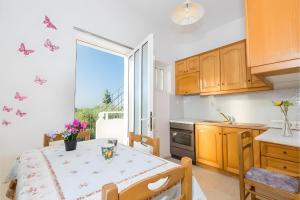 a kitchen with a table with butterflies on the wall at Tamar Apartments, Laganas in Laganas