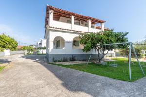 a house with a swing in front of it at Olivea Studio 2 in Acharavi