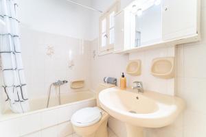 a white bathroom with a sink and a toilet at Olivea Studio 2 in Acharavi +16 photos
