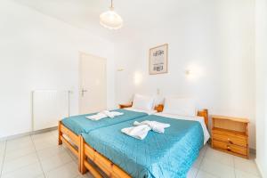 a bedroom with a blue bed with towels on it at Olivea Studio 2 in Acharavi