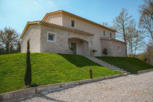 a house on top of a grassy hill at Villa Lapidea in Bezjaki