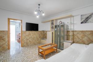 a bedroom with a bed and a tv and a table at Geranio in Caserío Bacarot