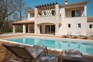 a villa with a swimming pool and a house at Villa Lapidea in Bezjaki