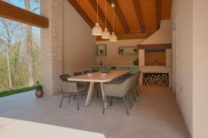 a dining room with a wooden table and chairs at Villa Lapidea in Bezjaki