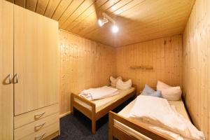 a room with two beds in a wooden cabin at Bungalow 37b - Kimbucht in Reichendorf