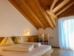a bedroom with a bed and a desk and a window at Residence Linderhof in Natz-Schabs