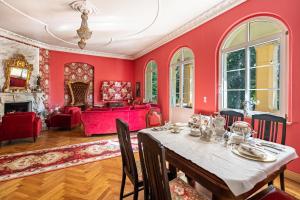 a dining room with red walls and a table with chairs at Ferienwohnung im Landschloss in Calau