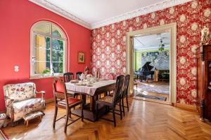 a dining room with red walls and a table and chairs at Ferienwohnung im Landschloss in Calau +24 photos