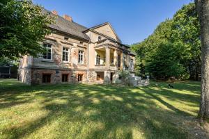 an old stone house with a large grass yard at Ferienwohnung im Landschloss in Calau