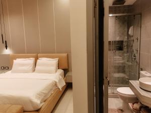 a bedroom with a bed and a bathroom with a shower at The Grand Elite Cairo Hotel in Cairo +33 photos