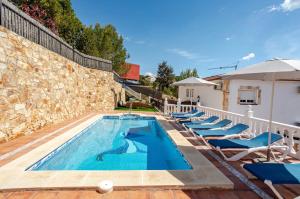 a pool with lounge chairs and a villa at Villa Mansory in Lloret de Mar