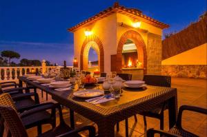 a long table with plates and wine glasses on a patio at Villa Mansory in Lloret de Mar