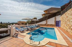 a pool at a villa with lounge chairs at Villa Mansory in Lloret de Mar