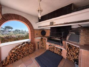 an outdoor kitchen with a pile of fire wood at Villa Mansory in Lloret de Mar