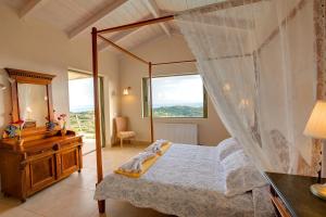 a bedroom with a canopy bed and a dresser and a window at Villa Corali Ideales Resort in Kefallonia +26 photos