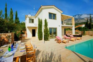 a villa with a swimming pool and a house at Villa Corali Ideales Resort in Kefallonia