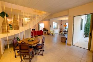 a dining room and living room with a table and chairs at Villa Corali Ideales Resort in Kefallonia
