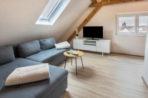 a living room with a blue couch and a tv at Ferienwohnung Degen in Donaueschingen