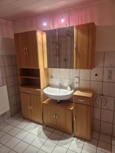 a bathroom with a sink and a mirror at Ferienhof Rosenwarft in Pellworm +38 photos