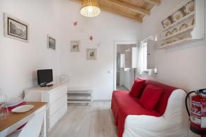 a living room with a red couch and a table at Páteo da Várzea 2 in Colares