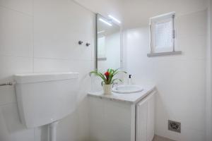a white bathroom with a sink and a mirror at Páteo da Várzea 2 in Colares +12 photos