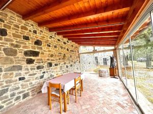 a table and chairs on a patio with a stone wall at La casa della nonna in Serramazzoni +8 photos