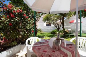 a table and chairs under an umbrella on a patio at Páteo da Várzea 2 in Colares
