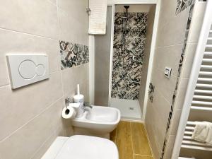 a bathroom with a white toilet and a sink at La casa della nonna in Serramazzoni