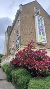 a building with a bunch of flowers in front of it at Modern 2 bed flat with parking by Bluewater shopping mall in Greenhithe