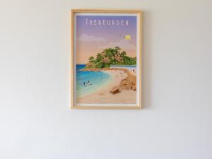 a framed picture of a beach on a wall at Pieds Dans L'eau Madame est Servie in Trébeurden