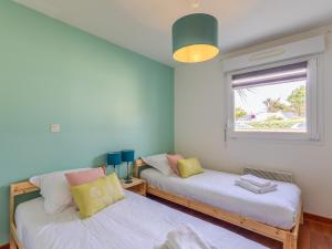 a room with two beds and a window at Pieds Dans L'eau Madame est Servie in Trébeurden
