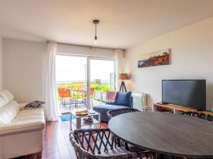 a living room with a table and a tv at Pieds Dans L'eau Madame est Servie in Trébeurden