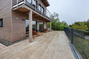 an outdoor patio with benches and a balcony at Ferienhaus mit Panoramablick in Gernrode