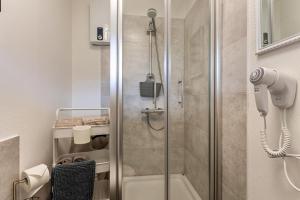 a shower with a glass door in a bathroom at Berg und Tal Apartment in Brilon +12 photos